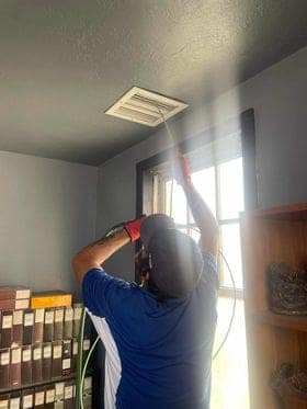 Fresh Ducts technician cleaning a residential ceiling register